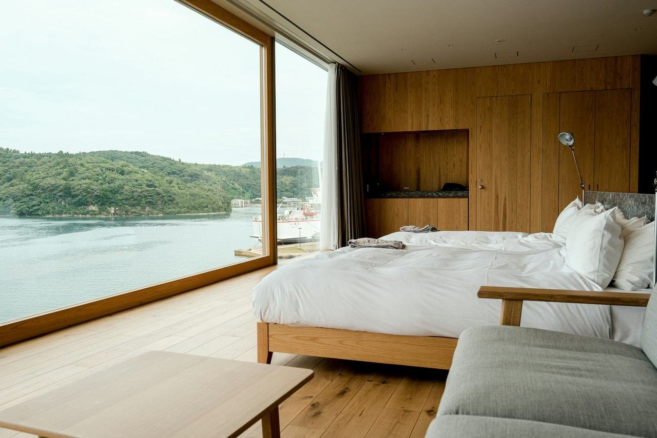 Habitación con ventanal panorámico sobre el lago y cama grande